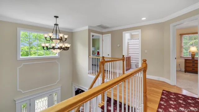 a view of a hallway with wooden floor and stairs