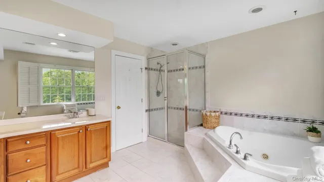 a bathroom with a tub sink a window and a shower