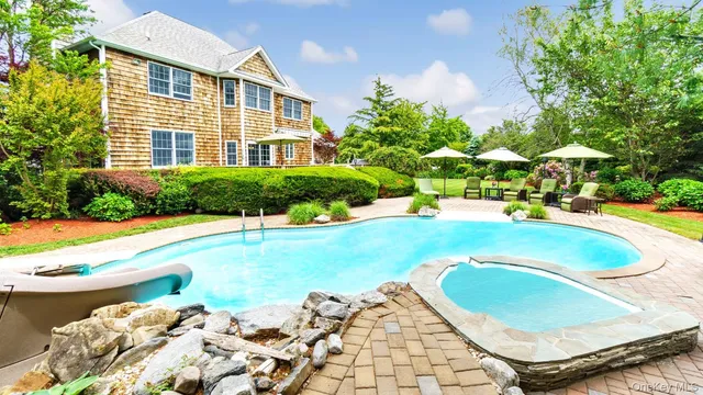 a view of a house with swimming pool and sitting area