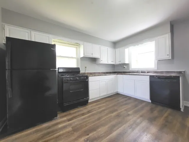 a kitchen with granite countertop stainless steel appliances and white cabinets