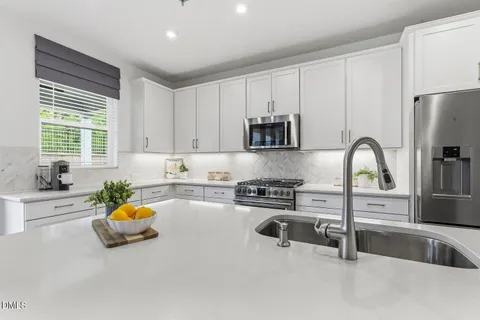 a kitchen with white cabinets and stainless steel appliances