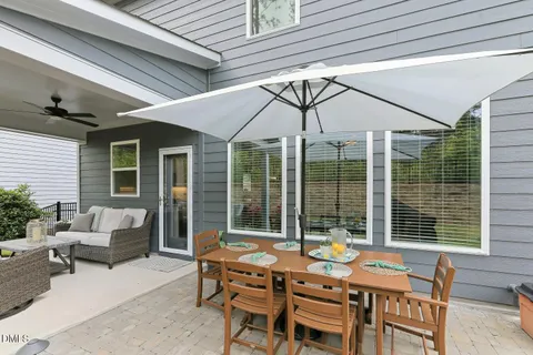 a view of a patio with couches table and chairs and potted plants