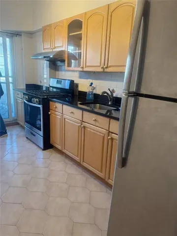 a kitchen with stainless steel appliances granite countertop a sink stove and cabinets