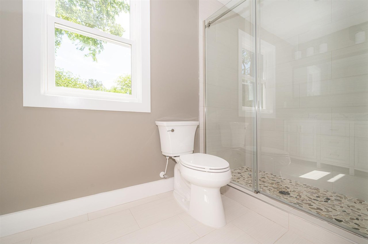1210 Boyer Street Raleigh, NC 27610 - Photo 13 of 24 tile floor, pebble shower bed, glass sliding doors masterbathroom