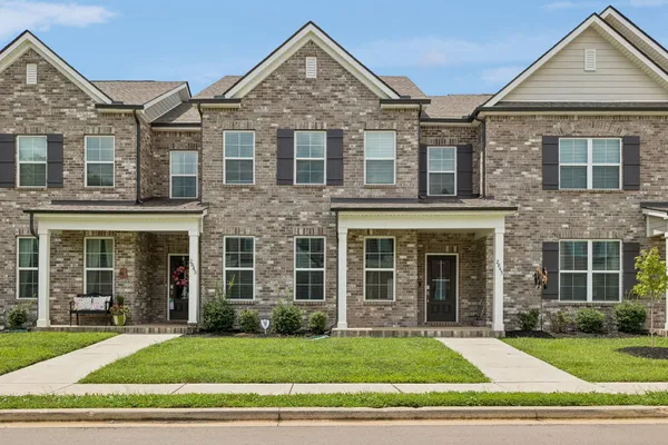 a view of a brick house with a yard