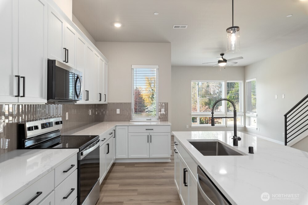 6609 South 128th Street Seattle, WA 98178 - Photo 12 of 28 a kitchen with a sink stove and microwave