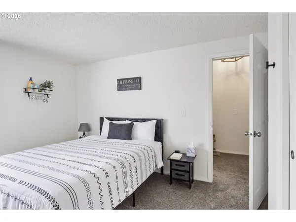 a bedroom with a bed and a painting on the wall