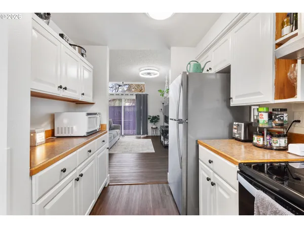 a kitchen with granite countertop a refrigerator stove and sink