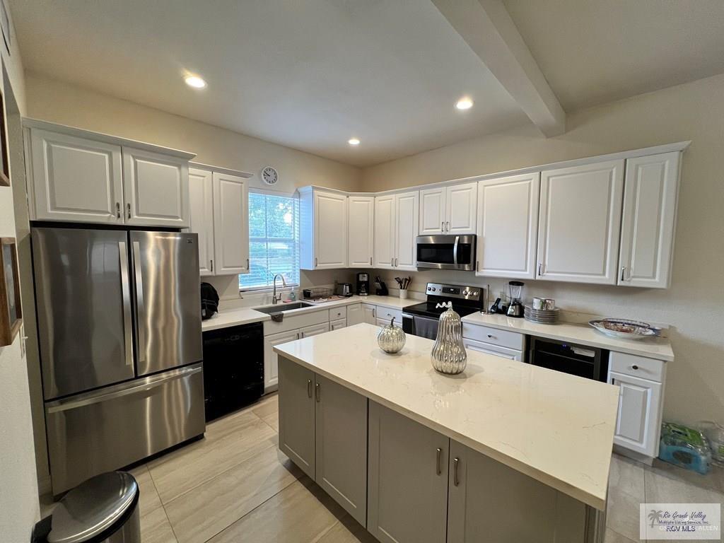 4601 Carmen Avenue Olmito, TX 78575 - Photo 38 of 45 a kitchen with refrigerator a stove a sink and white cabinets