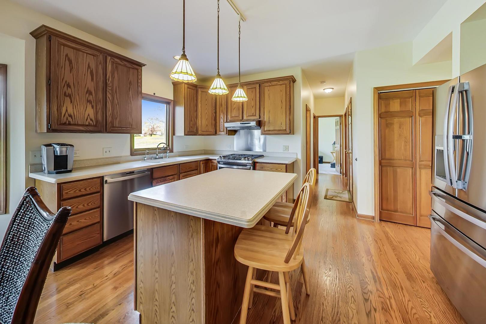 39898 North Harbor Ridge Drive Antioch, IL 60002 - Photo 5 of 27 a kitchen with a table chairs refrigerator and sink