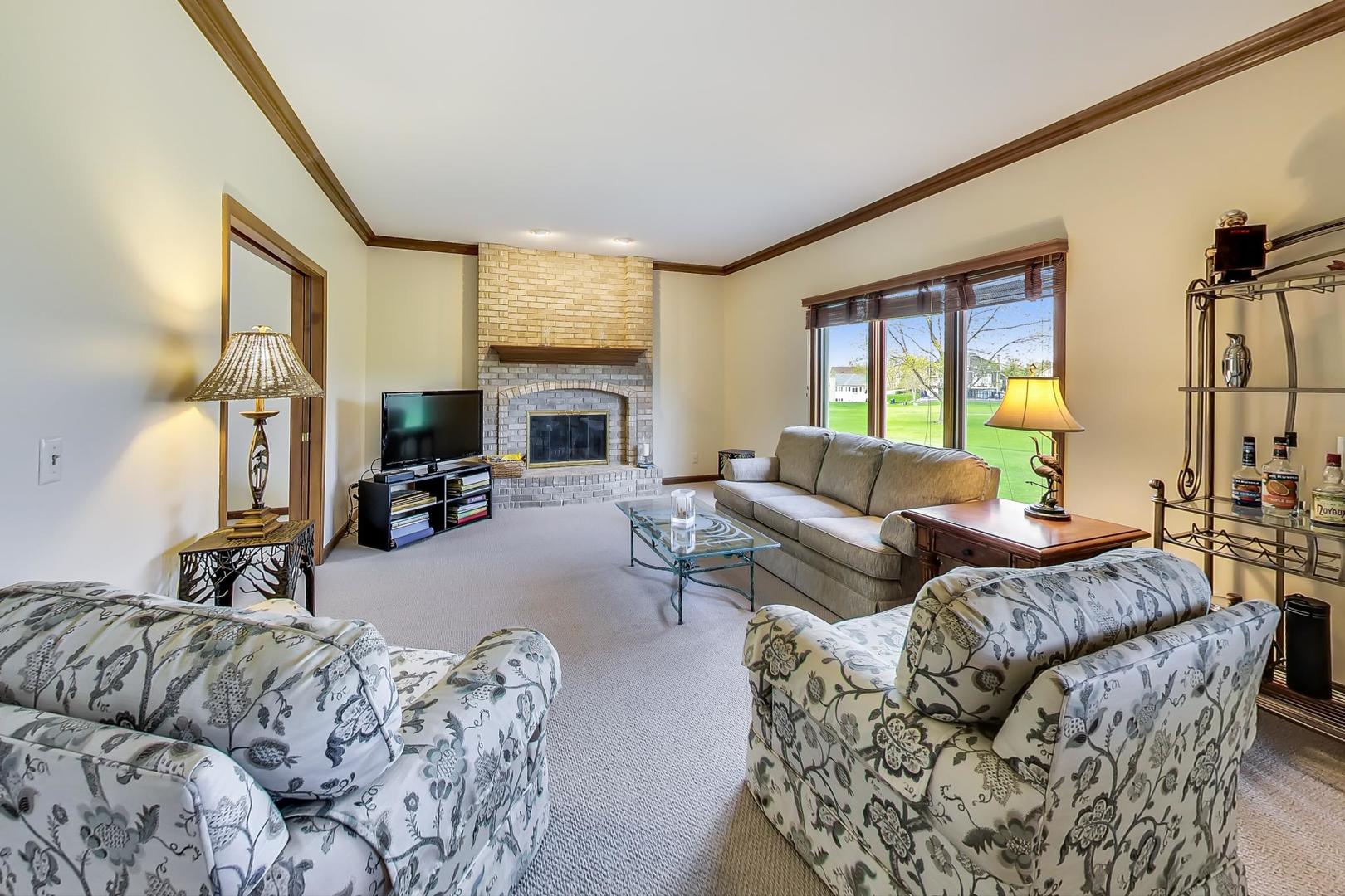 39898 North Harbor Ridge Drive Antioch, IL 60002 - Photo 8 of 27 a living room with furniture fireplace and a large window