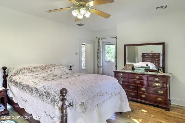 a bedroom with a bed and wooden floor