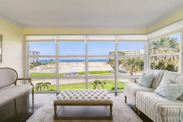 a front view of a house with a yard and potted plants