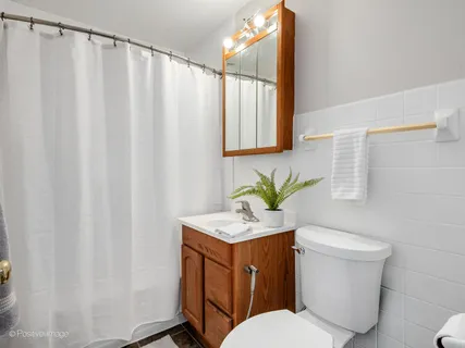 a bathroom with a granite countertop sink and a toilet