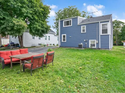 a backyard of a house with yard and outdoor seating