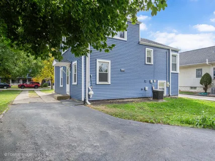 a view of a house with backyard and a tree