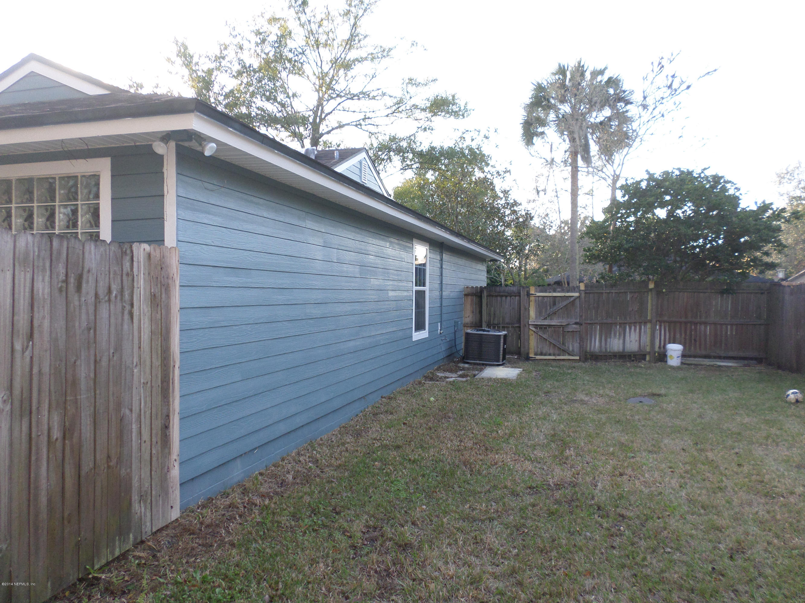 11063 Reading Road Jacksonville, FL 32257 - Photo 4 of 23 a view of a small house with a large tree and wooden fence