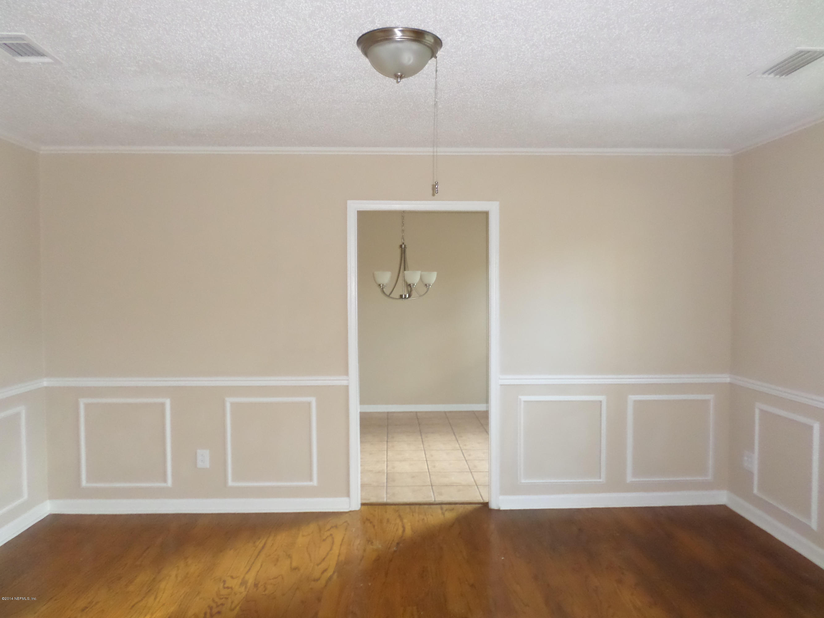 11063 Reading Road Jacksonville, FL 32257 - Photo 6 of 23 a view of an empty room with wooden floor and cabinet