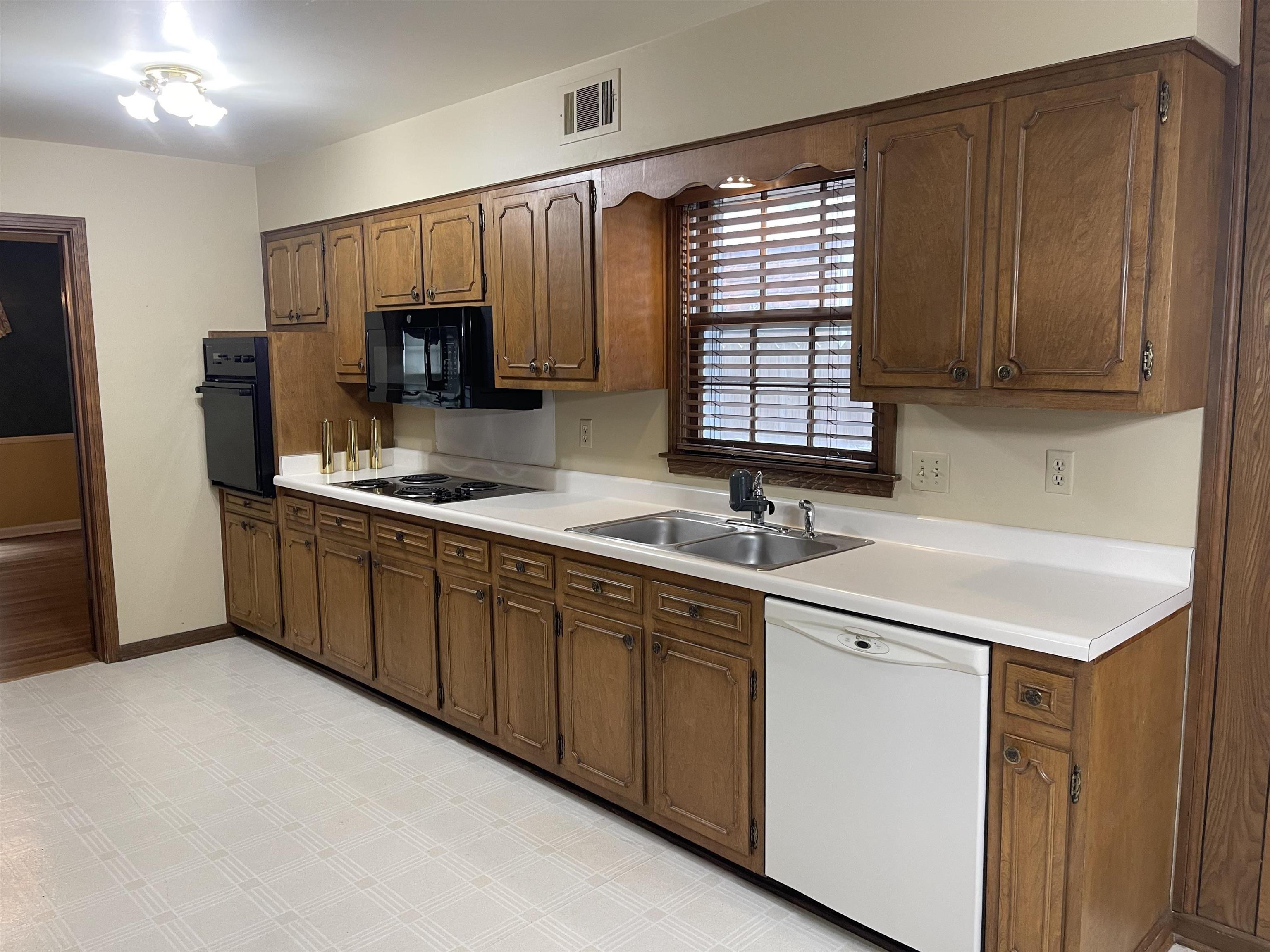 379 McElroy Road Memphis, TN 38120 - Photo 11 of 19 Kitchen with black appliances, light countertops, and brown cabinets