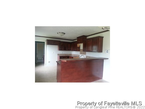 3224 Rozier Siding Road St. Pauls, NC 28384 - Photo 7 of 19 a kitchen with kitchen island stainless steel appliances a sink and cabinets