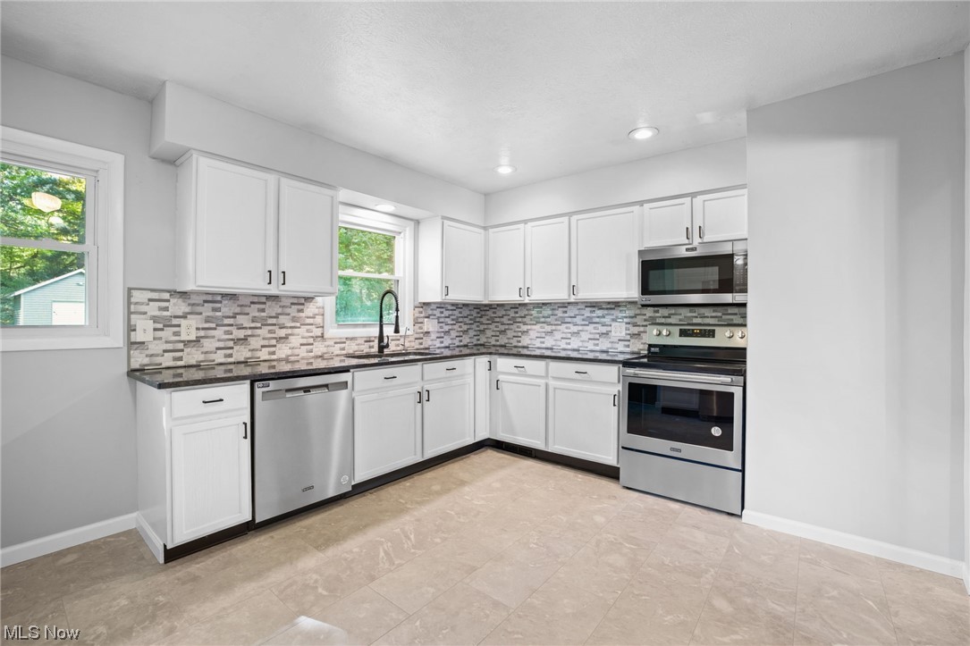 730 East Nimisila Road Uniontown, OH 44685 - Photo 10 of 25 Kitchen with appliances with stainless steel finishes, white cabinetry, and sink