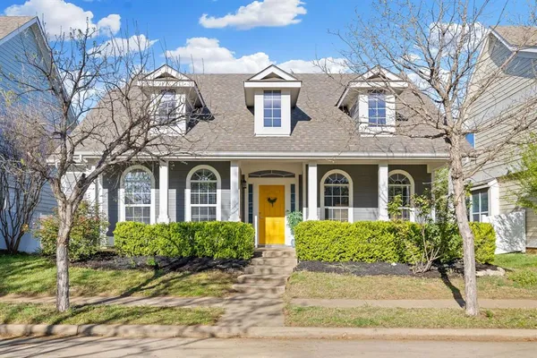 a front view of a house with yard and trees