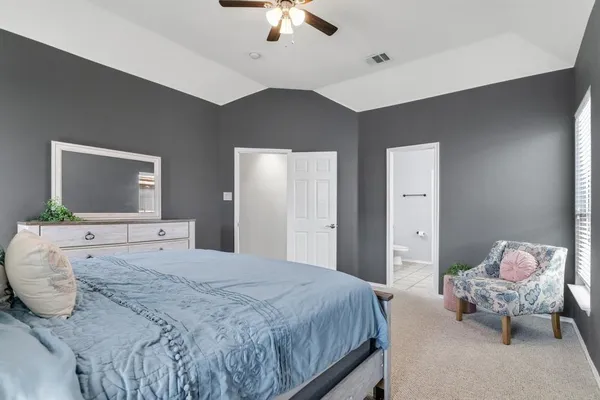 a spacious bathroom with a double vanity sink a toilet and a mirror