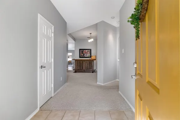a view of a hallway with wooden floor and a bathroom