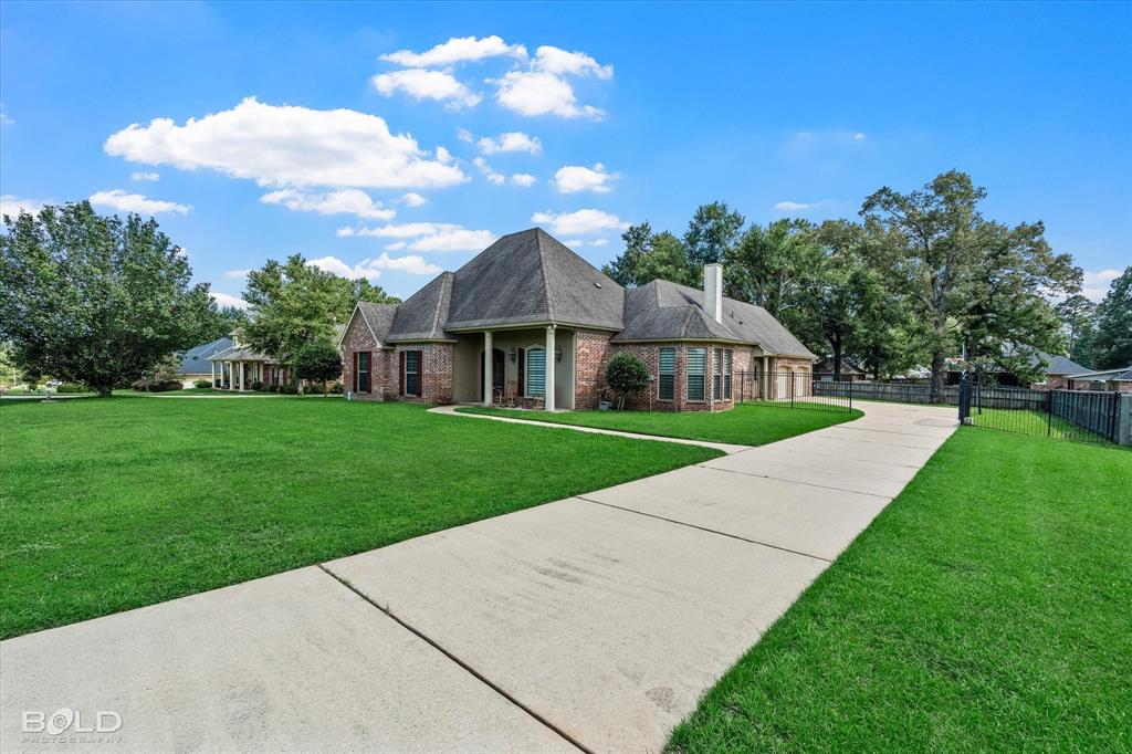 2220 Forest Hills Boulevard Haughton, LA 71037 - Photo 2 of 40 Brick exterior with dark shutters, gabled roofline, and a concrete driveway