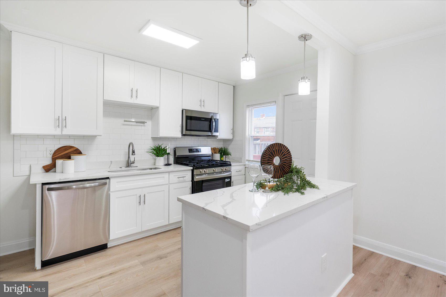 1324 Winston Avenue Baltimore, MD 21239 - Photo 12 of 33 a kitchen with stainless steel appliances a sink a stove cabinets and a refrigerator