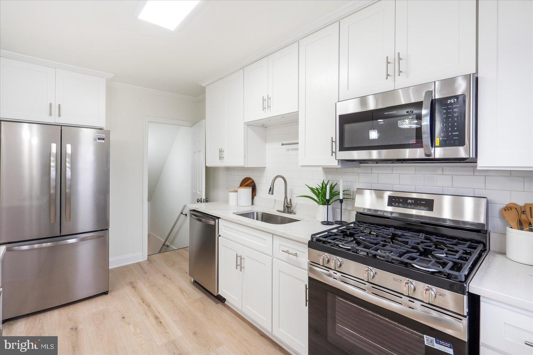 1324 Winston Avenue Baltimore, MD 21239 - Photo 15 of 33 a kitchen with stainless steel appliances granite countertop a stove a refrigerator and a microwave