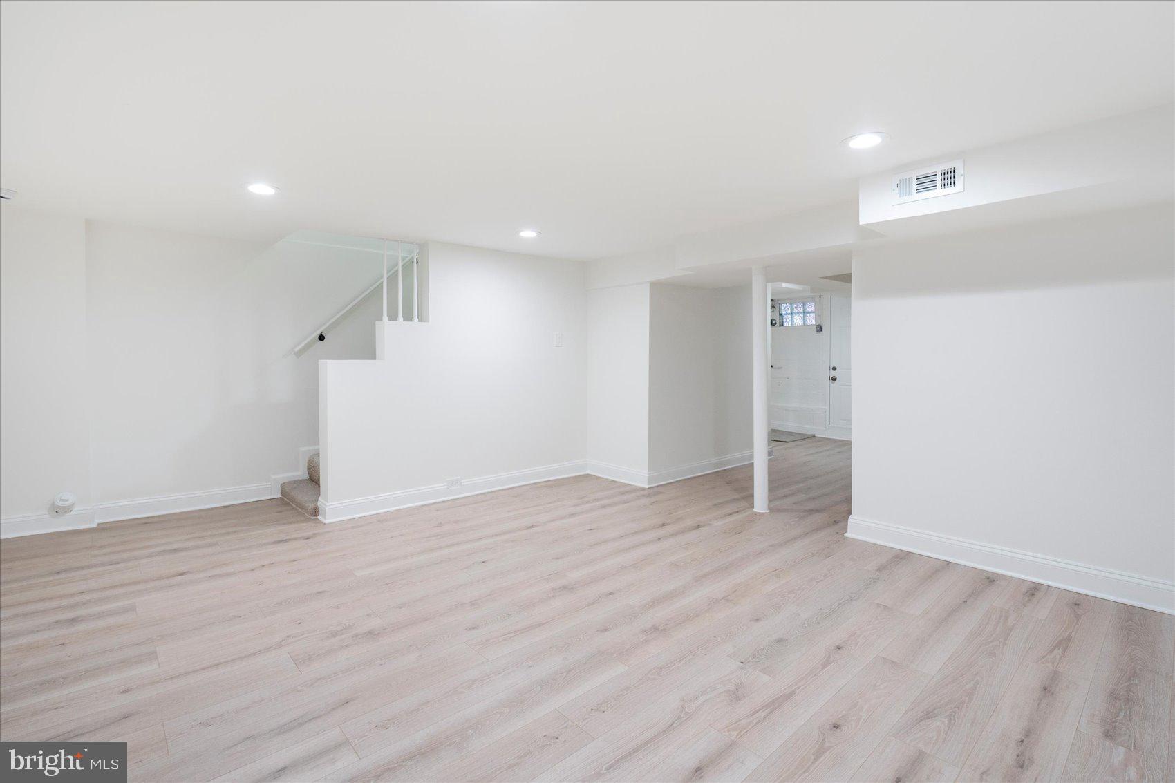 1324 Winston Avenue Baltimore, MD 21239 - Photo 27 of 33 an empty room with wooden floor and windows