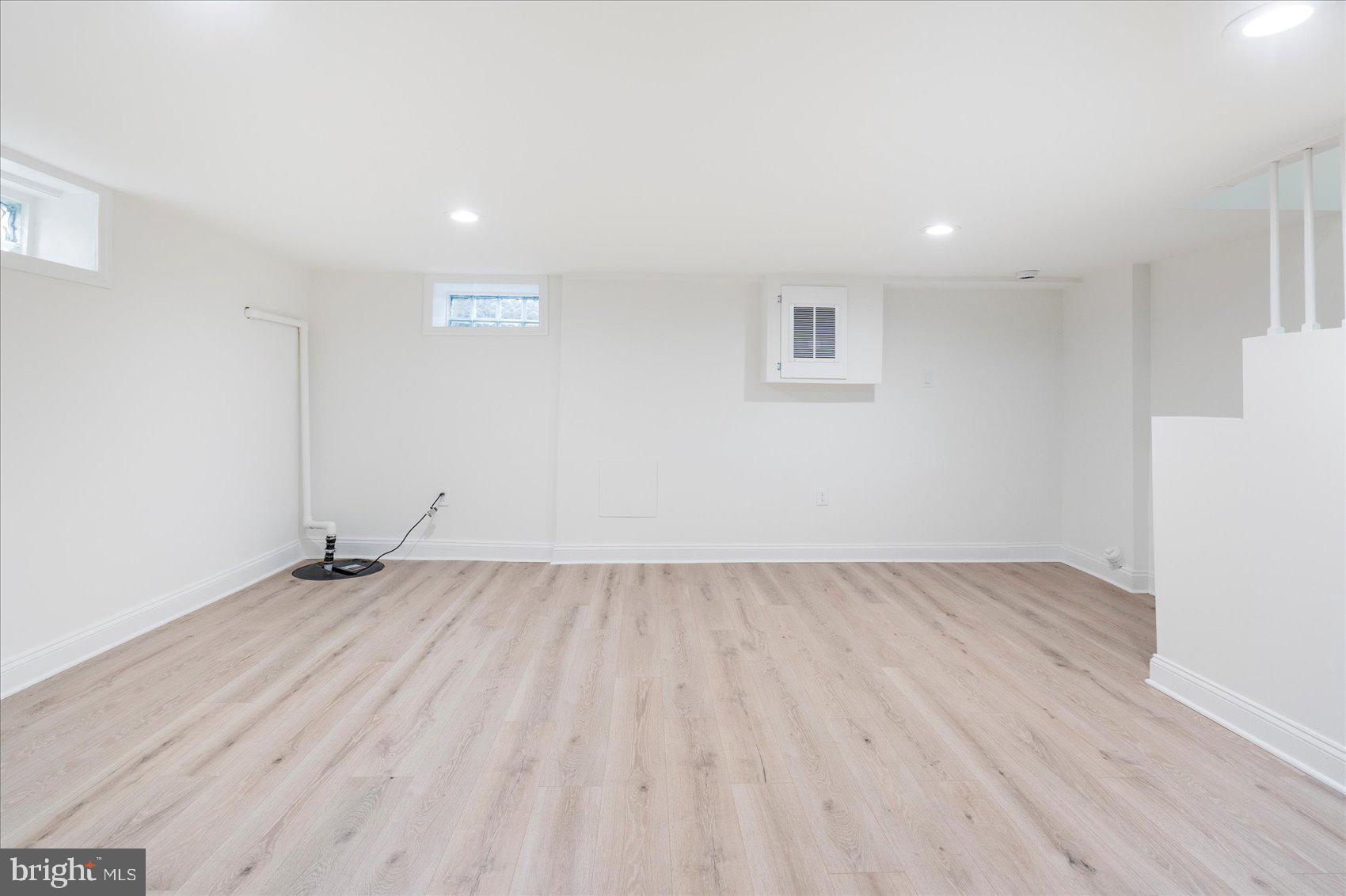 1324 Winston Avenue Baltimore, MD 21239 - Photo 28 of 33 an empty room with wooden floor and windows
