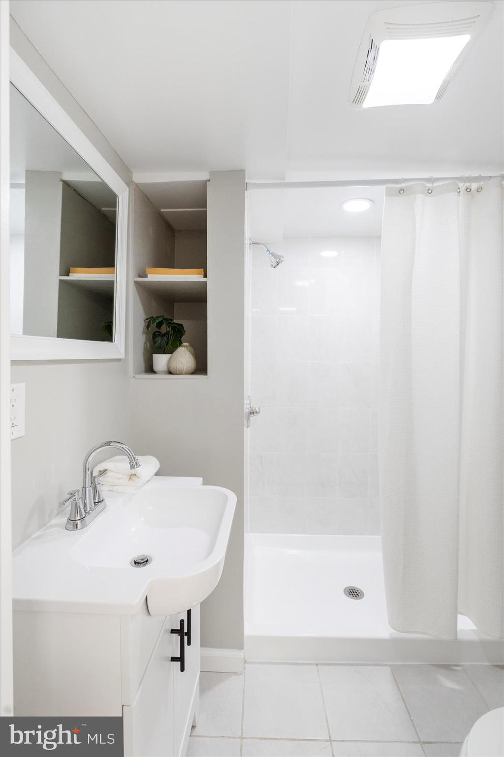 1324 Winston Avenue Baltimore, MD 21239 - Photo 31 of 33 a bathroom with a sink a shower and a mirror