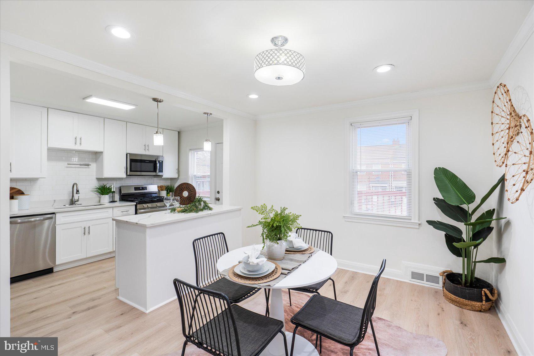 1324 Winston Avenue Baltimore, MD 21239 - Photo 10 of 33 a kitchen with white cabinets and wooden floor