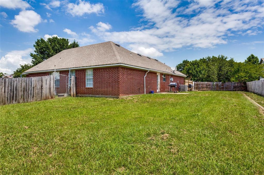 1008 Treys Court Sanger, TX 76266 - Photo 11 of 11 Rear view of house featuring a fenced backyard, brick siding, and a shingled roof