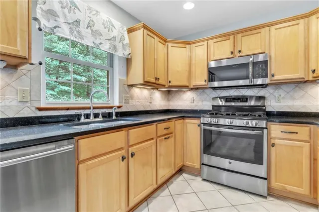 a kitchen with stainless steel appliances a stove sink and microwave