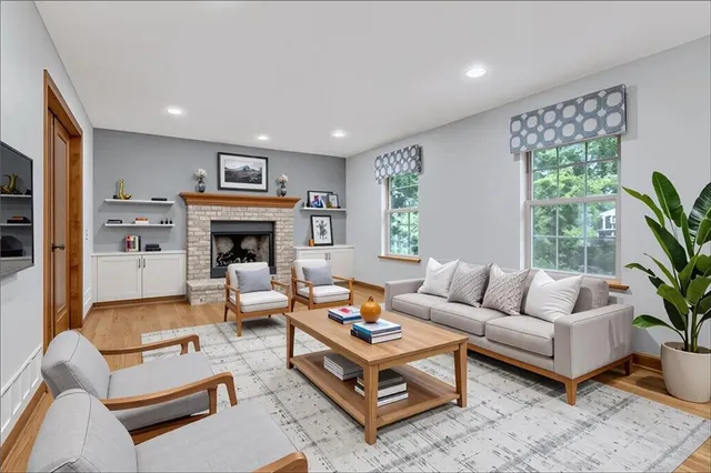 a living room with furniture fireplace and a large window