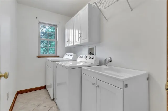 a utility room with cabinets washer and dryer