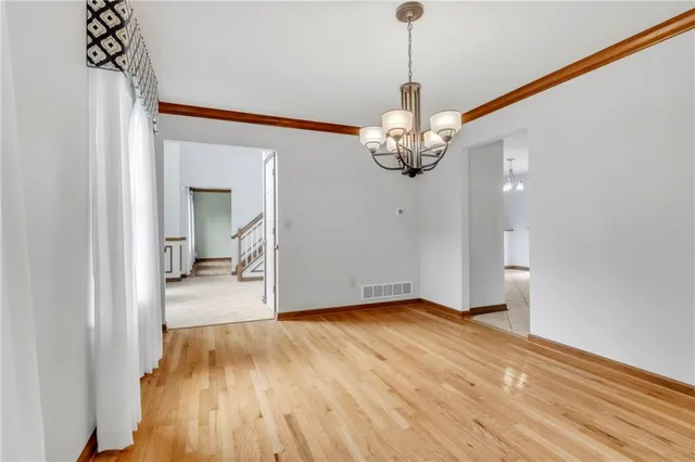 a view of a room with wooden floor and chandelier