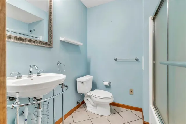 a bathroom with a toilet a sink and mirror
