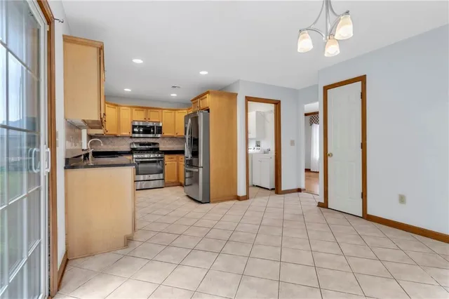 a kitchen with stainless steel appliances granite countertop a refrigerator and a stove top oven