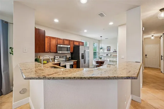 a kitchen with stainless steel appliances granite countertop a sink refrigerator and cabinets