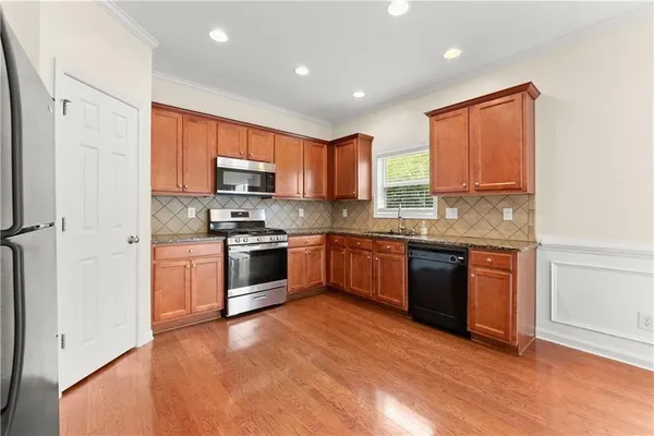 a kitchen with stainless steel appliances granite countertop a stove sink and microwave