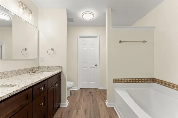 a bathroom with a granite countertop sink a mirror and a bathtub