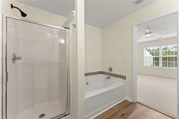 a white bath tub sitting next to a shower