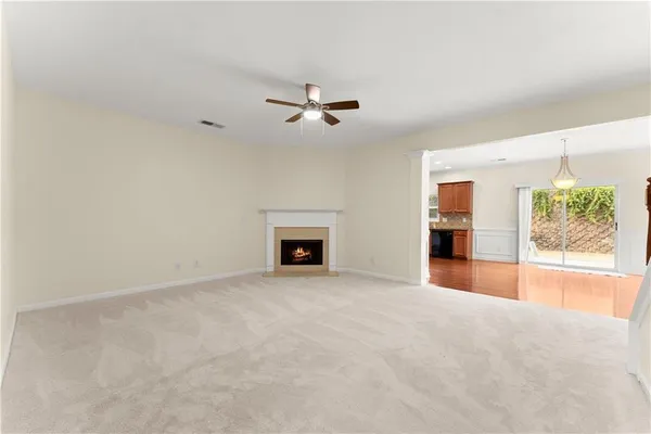 an empty room with windows and fireplace