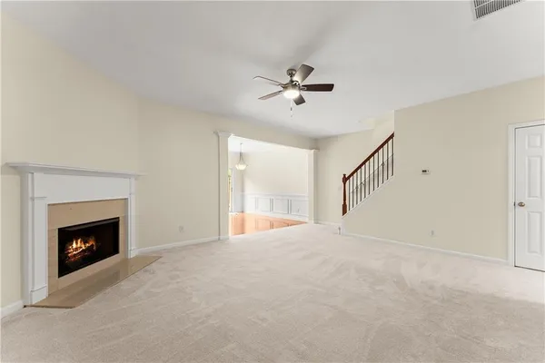 a view of empty room with fireplace and fan
