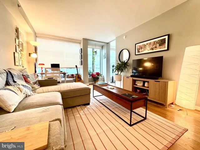 a living room with furniture a flat screen tv and a table