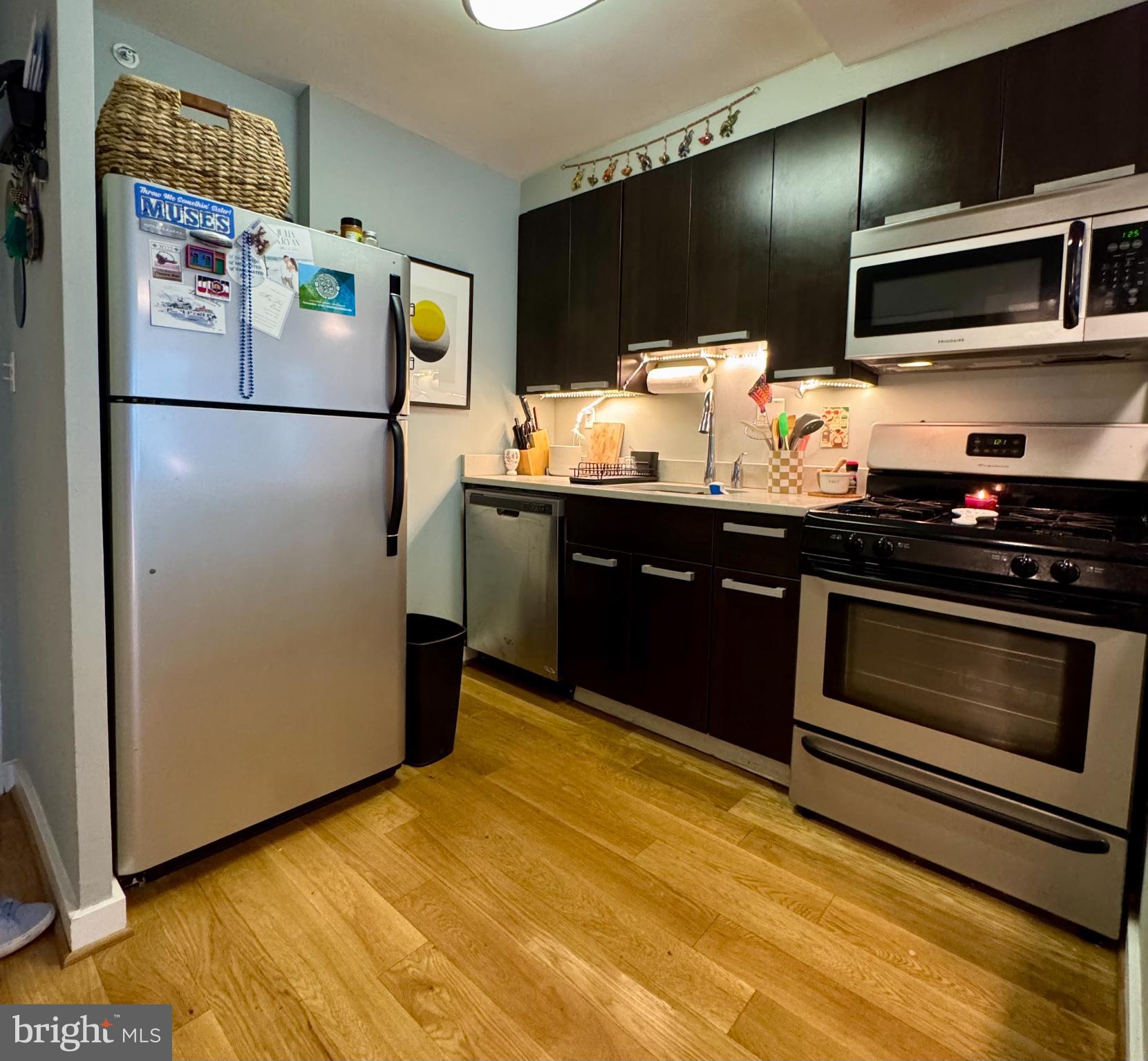 1101 3rd Street Southwest, Unit 509 Washington, DC 20024 - Photo 14 of 28 a kitchen with granite countertop wooden cabinets and stainless steel appliances